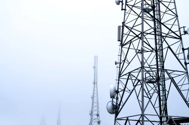 Telecommunications tower in foggy weather, with more towers visible in the distance